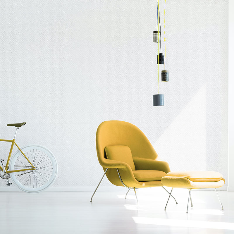 Red bicycle and armchair under lamp in white minimal apartment i